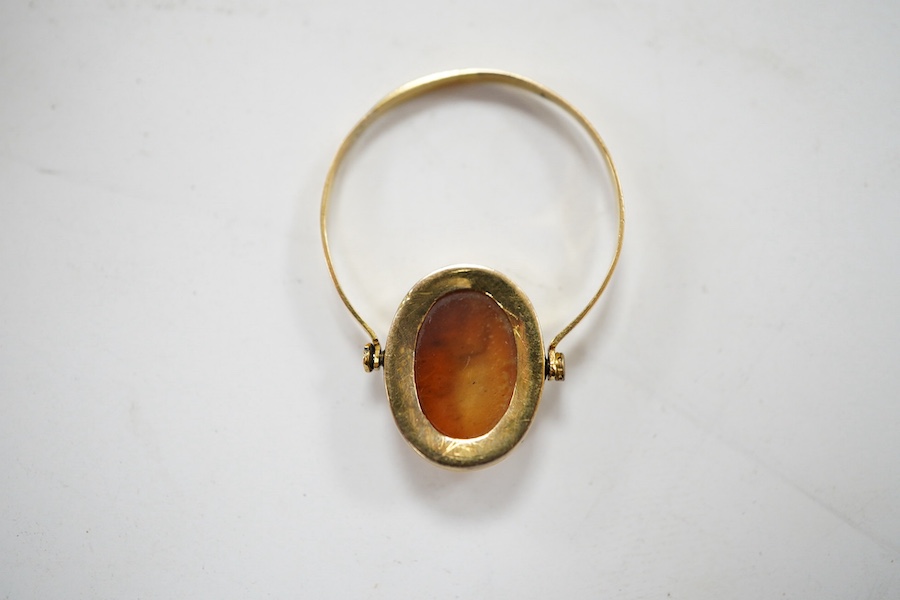 A 19th century French? yellow metal and oval intaglio paste set swivelling ring, size N, gross weight 1.2 grams. Condition - poor to fair